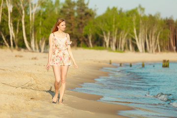 Summer vacation. Girl walking alone on the beach.