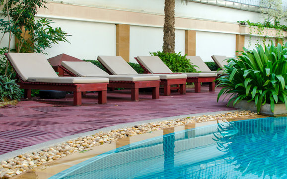 Beach chairs near swimming pool in tropical resort