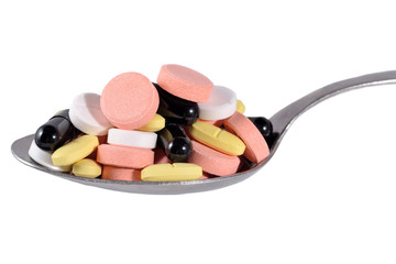 Many colorful pills in spoon