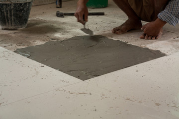 He use trowel  to tiled