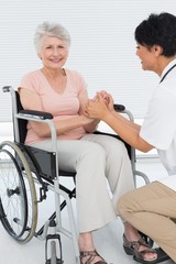 Doctor talking to a senior patient in wheelchair