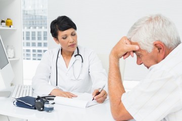 Doctor explaining reports to worried senior patient