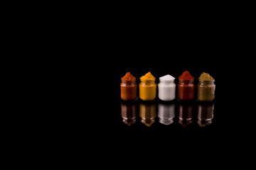 Mixed spices and salt over black background