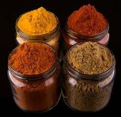 Mix powdered spices in glass container over black background