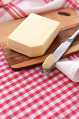 Tasty butter on wooden cutting board