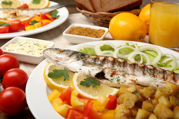 Delicious grilled fish on plate on table close-up