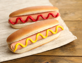 Tasty hot dogs on wooden table