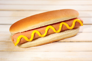 Tasty hot dog on wooden table