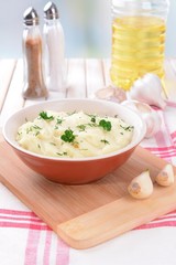 Delicious mashed potatoes with greens in bowl on table close-up