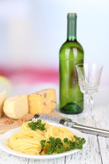 Composition with tasty spaghetti, grater, cheese, wine bottle