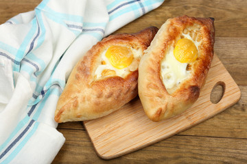 Ajarian khachapuri on wooden table close up