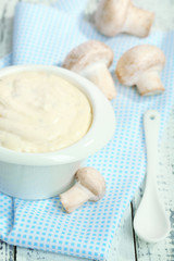 Delicate mushroom sauce in bowl on wooden table close-up