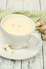 Delicate mushroom sauce in cup on wooden table close-up