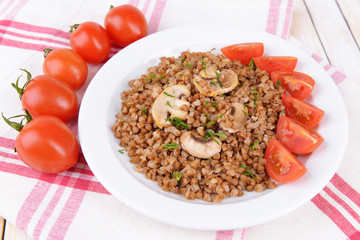 Boiled buckwheat on plate on table close-up