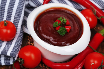 Tomato sauce in bowl on wooden table close-up