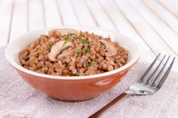 Boiled buckwheat in bowl on table close-up