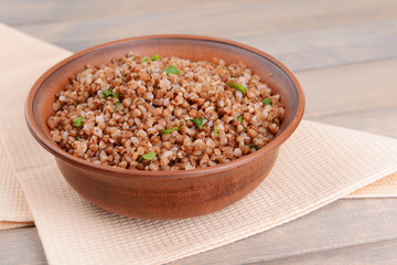 Boiled buckwheat in bowl on table close-up