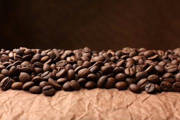 Coffee beans on table on brown background