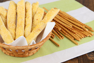 Bread sticks  in wicker basket on wooden background
