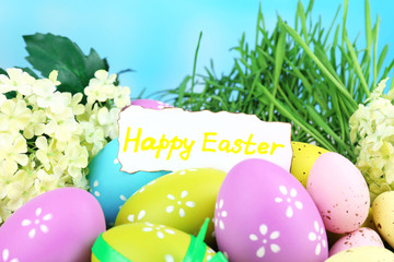 Easter composition with eggs on green grass, on blue background