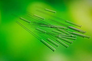 Needles for acupuncture on green background