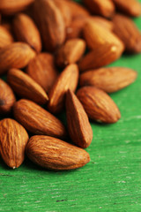 Almonds on color wooden background