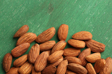Almonds on color wooden background