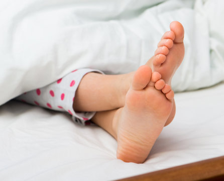 Baby bare feet on the bed