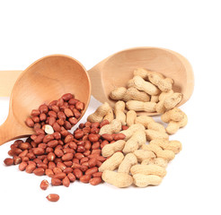 Two wooden spoons with peanuts