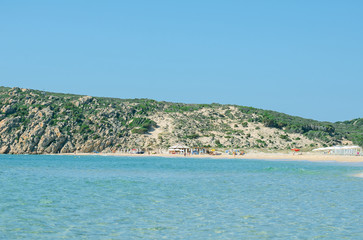 Obraz premium Tropical beach with deckchairs, umbrellas and people.