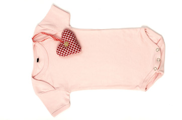 Close up of an pink baby bodysuit with a smal red heart on it