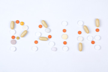 pain word text made of colorful tablets, pills and capsules