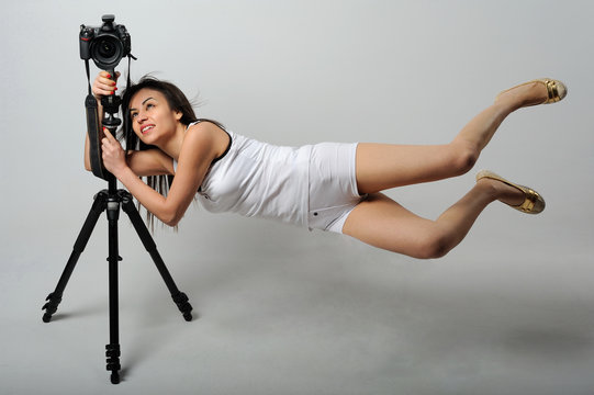 Photographer woman flaying with camera - levitation - Powered by Adobe