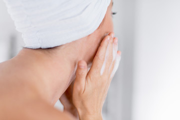 Fototapeta na wymiar Mature lady cleaning her skin and remove her make up
