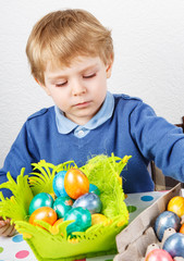 Fototapeta premium Little toddler boy being happy about selfmade Easter egg