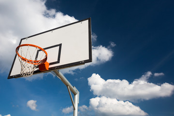 Naklejka premium Basketball hoop against lovely blue summer sky