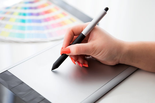 Graphic designer working on a digital tablet and with pantone pa
