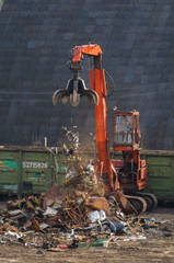 The handler of scrap loads with metal in the car