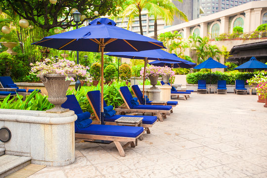 Beach chairs near swimming pool in luxury hotel