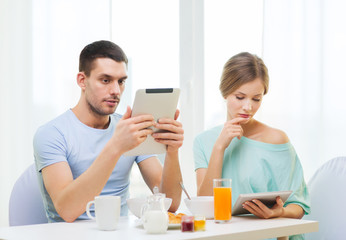 concentrated couple with tablet pc reading news