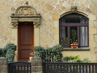 Handwerkskunst in einer alten Fassade aus hellem Naturstein und Bruchstein in Beige und Naturfarben...