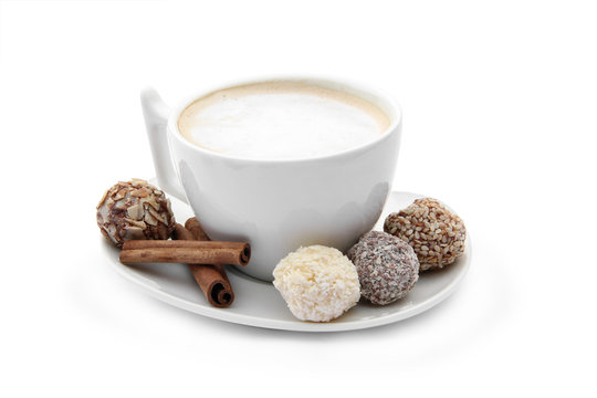cup of coffee with chocolate candies and cinnamon