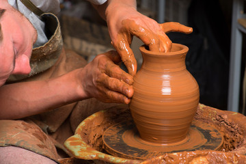 Fototapeta na wymiar hands of a potter, creating an earthen jar