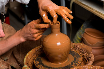 hands of a potter, creating an earthen jar