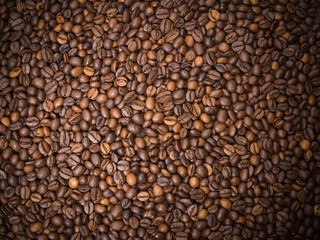 Numerous coffee beans which have been scattered all over the sur