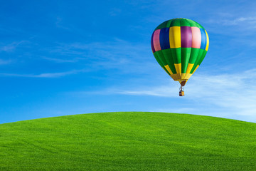 Hot air balloon over green field