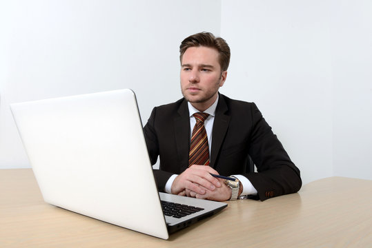 Young attractive businessman looking at computer