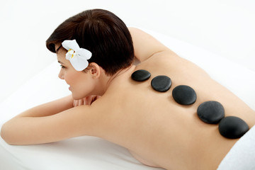 Obraz na płótnie Canvas Spa Tretment. Beautiful Woman Getting Stones Massage in Salon
