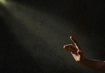 woman's hand reaches for the light rays