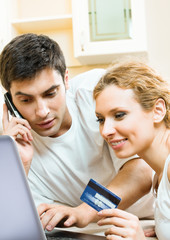 Cheerful couple paying by plastic card